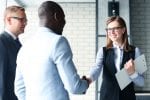 Smartly dressed woman shaking hands with man signifying training contract success via paralegal experience