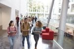 A group of three people are walking and talking together