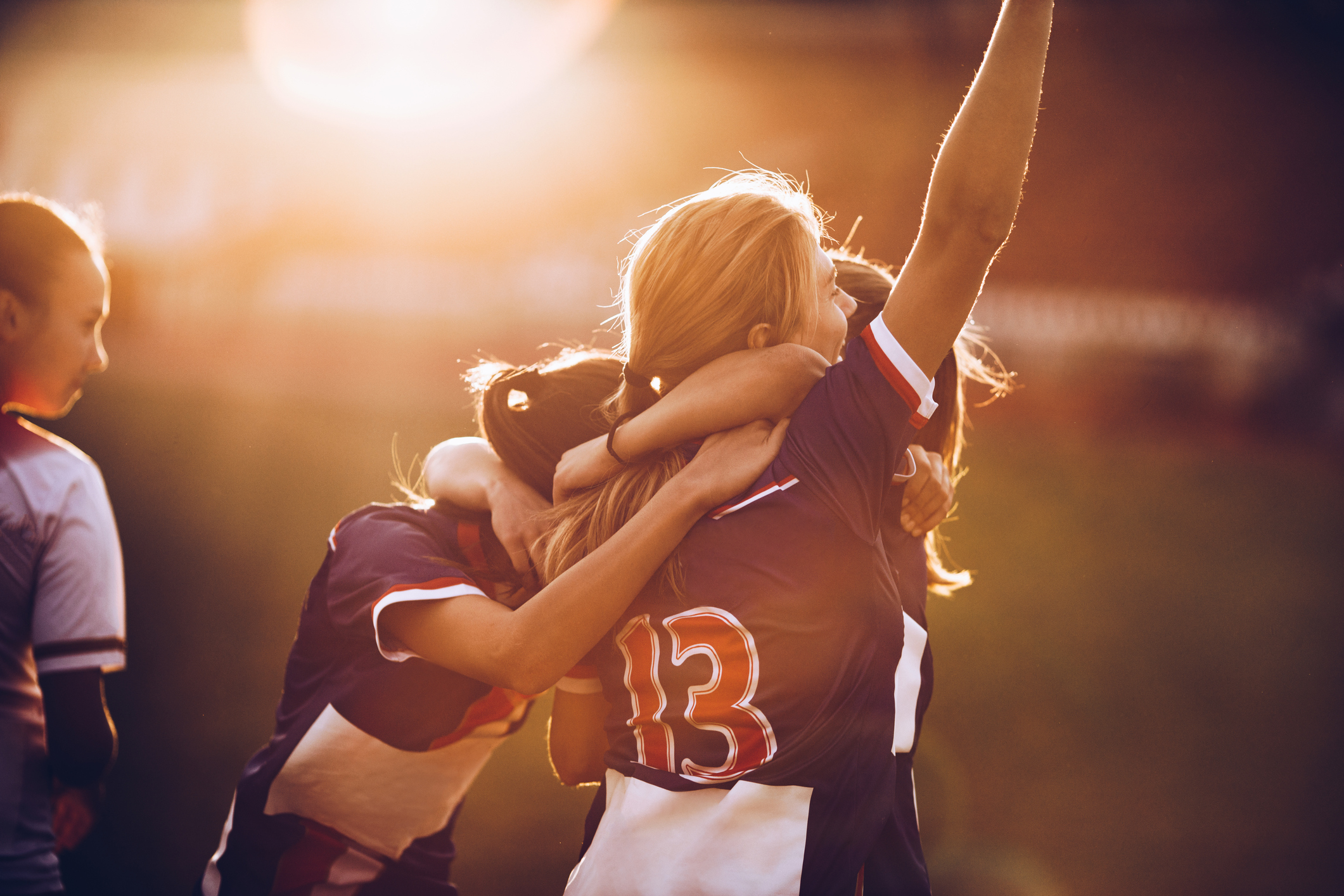A group of girls hug each other after receiving a good sport result