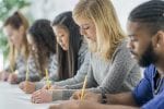 Three female students taking an exam