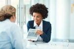 A lawyer shows her work on an ipad to another person
