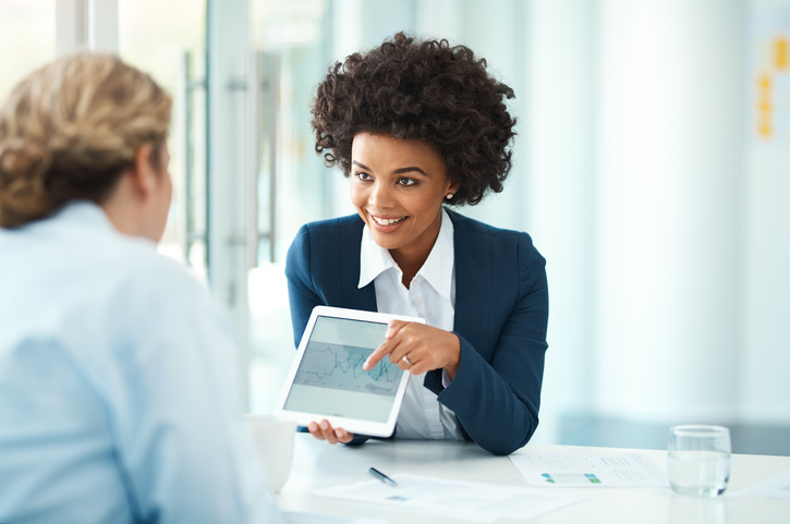 A lawyer shows her work on an ipad to another person