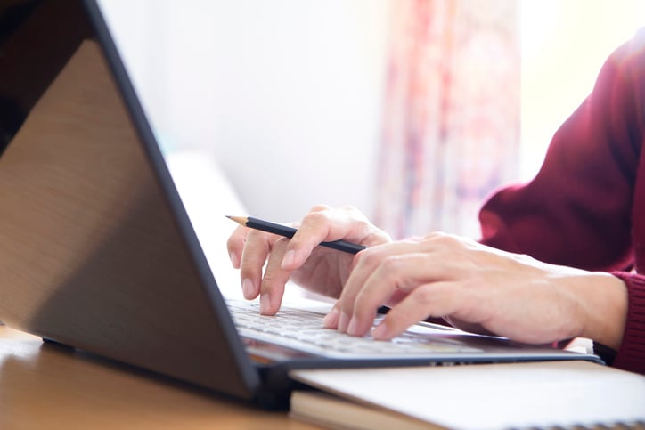 Close up of womans hands writing a legal document on a laptop