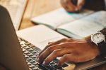 Close up of man writing a legal document on a laptop