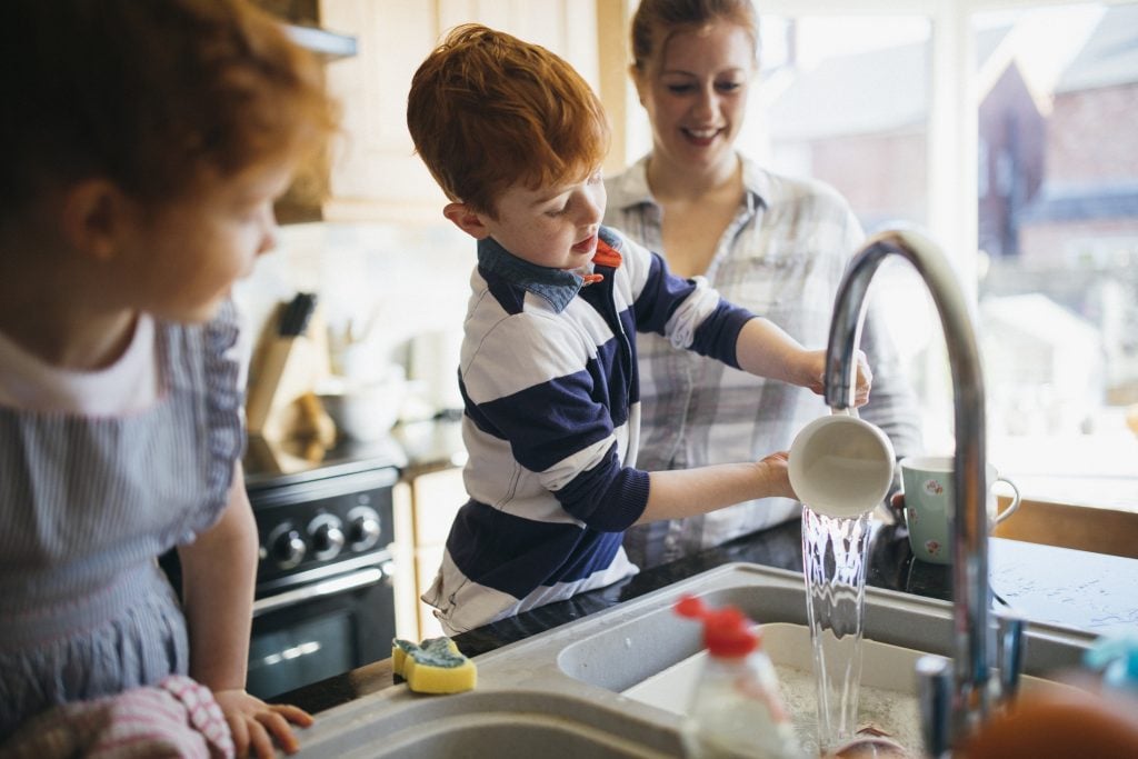 Young family washing dishes together