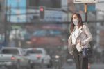 Woman with a facemask on in a busy street protects herself from the Coronavirus