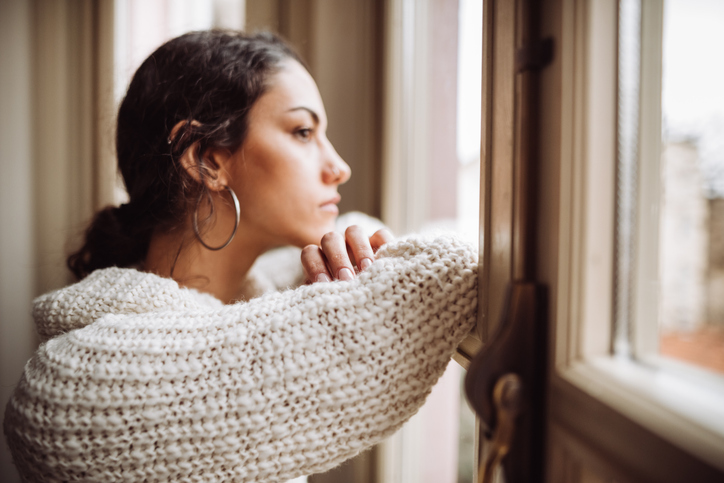 Young woman looking out of the window