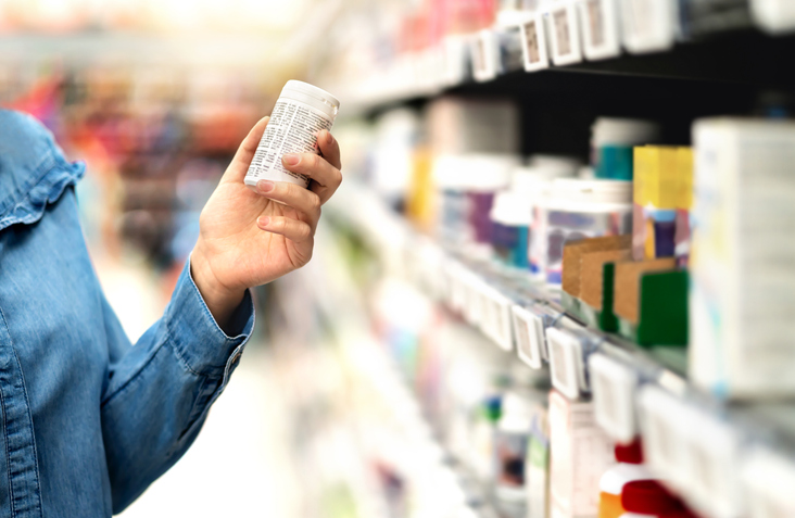 Close up of a hand holding pill box in a pharmacy