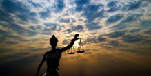 Lady justice statue against backdrop of a cloudy sunset