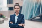 Young professional female standing outside a glass office building