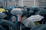 Crowd of people using umbrellas on a street during a storm