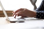 Close up of hands typing on a laptop