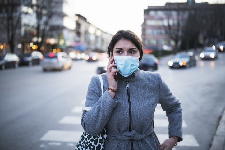 Lady walking down the street with a mask