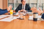 Employees at a law firm sat around a table discussing a case