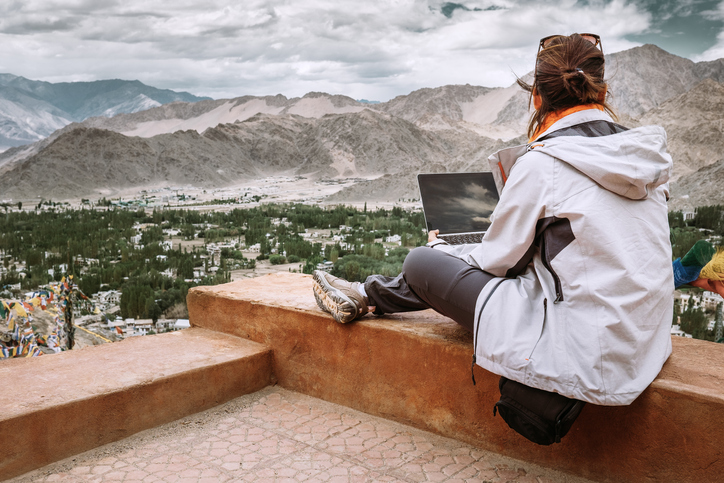 Girl on LLB law study abroad year holds laptop and looks at view